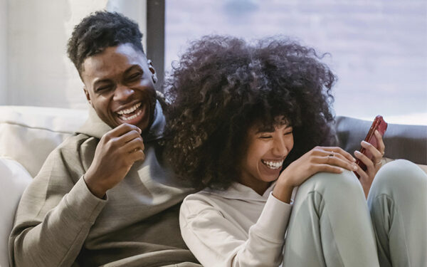 BIPOC couple laughing together. This represents how you can take the steps to deal with anxiety in a relationship and feel happier.