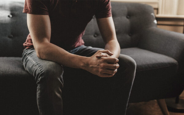 Man sitting on a therapist office ready to start therapy. This represents how knowing the warning signs can help you determine when it's time to seek out treatment for depression.