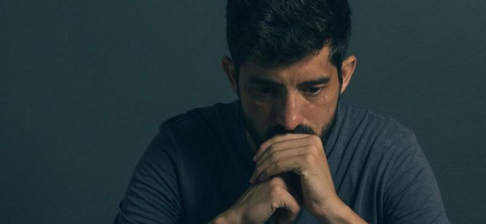 Man with chin in hands looking distraught before seeing a skilled psychologist in Baltimore, MD | Men's Therapy for Depression | Depression therapist in Baltimore, MD 21210 | New Connections Counseling Center" width="300" height="139"