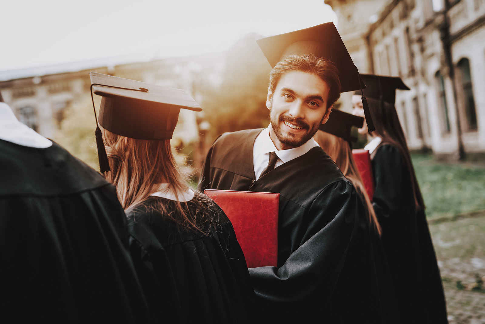 male student in a black cap and gown graduates from college. He feels confident about his career choices and graduating after therapy for college students in baltimore, MD 21210 at new connections counseling center " width="300" height="200"