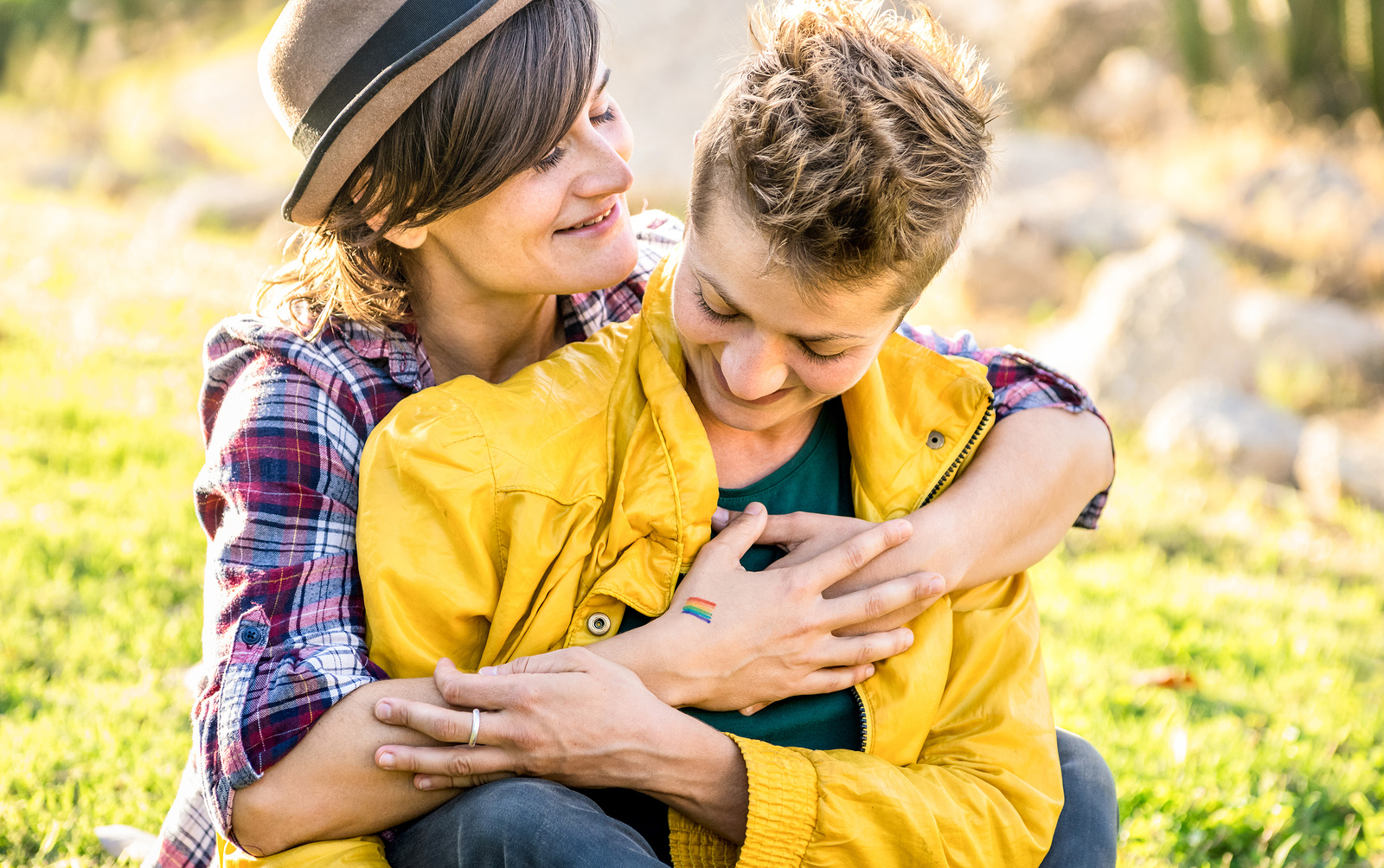 lesbian couple in the park hugging and looking in love | Counseling for life transition in Baltimore, MD 21210 | Coming out in therapy | LGTBQ affirming therapist" width="300" height="188" 