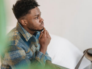 Photo of a black young man with a thoughtful and focused look. This represents how it can be helpful to think if anxiety is always a bad thing and how we can use it to our advantage.