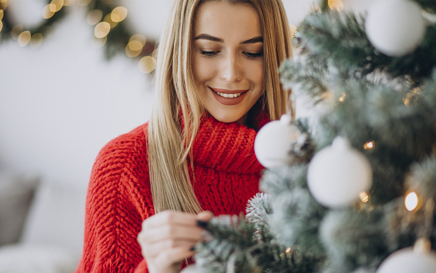 Woman decorating her Christmas tree. This represents how there are a lot of fun holiday(ish) ideas in and outside of Baltimore you can enjoy alone or with the ones you love.