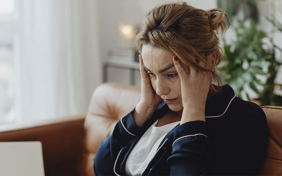 Woman with her hands holding her head with a tired and preoccupied expression. This represents how depression affects the brain, including cognitive tasks and social interactions.