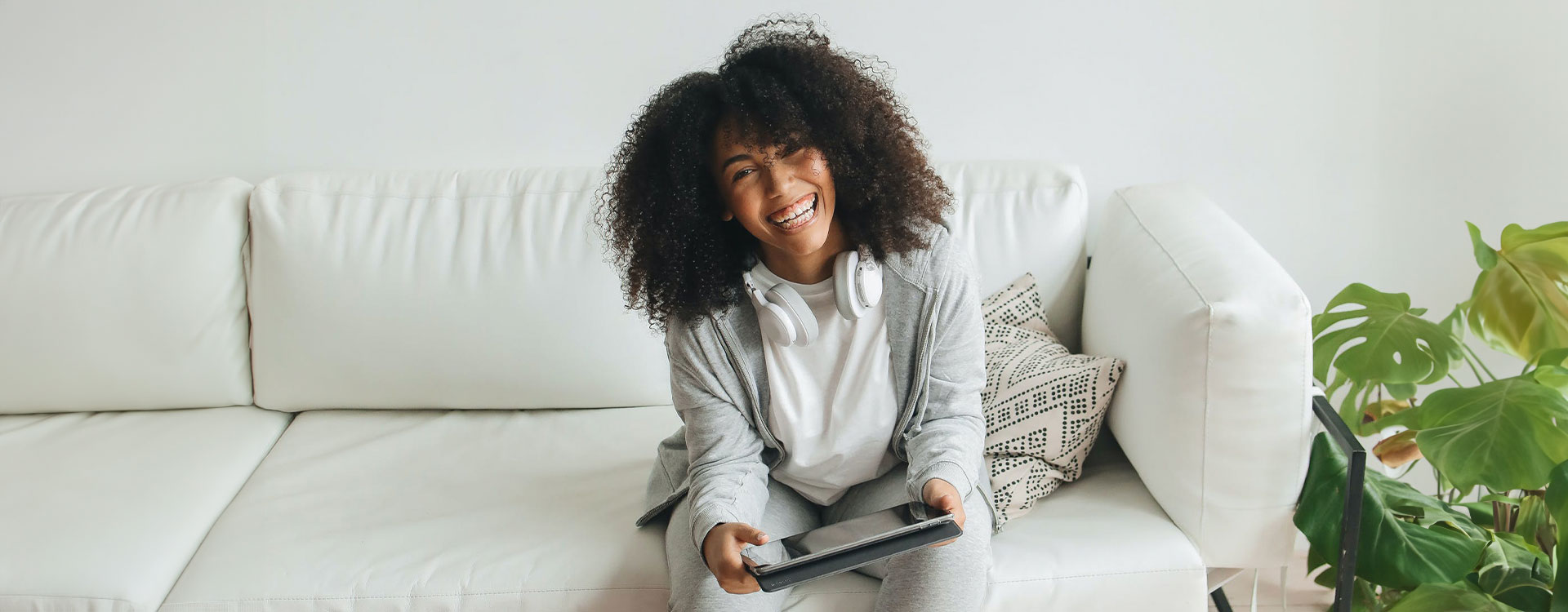 Photo of a black woman sitting in the couch with a relaxed and happy expression after reading our anxiety ebook. This represents how you can overcome stress and anxiety and feel better and more connected with yourself.
