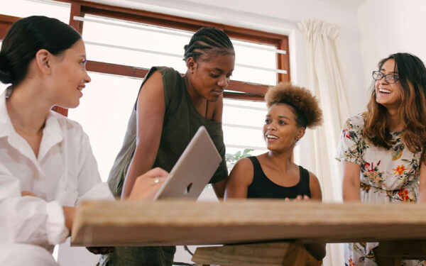 Photo of a group of women working together. This represents how empowering women to prioritize their mental health and cultivate stress management strategies is essential for a healthier, more connected life.