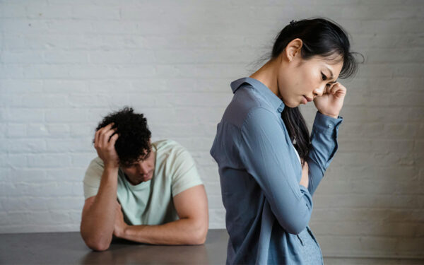 Photo of a couple looking upset and worried after a fight. This represents how it is crucial to be aware and identify relationship red flags.