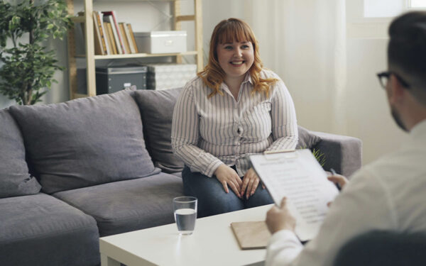 Photo of a woman in her first therapy session, after adjusting her insurance benefits in open enrollment and finding the right therapist for her needs.