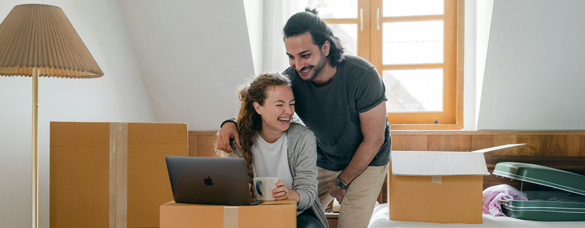 Happy couple surrounded by boxes, moving into their new home, representing how relationship counseling fosters healthier connections.