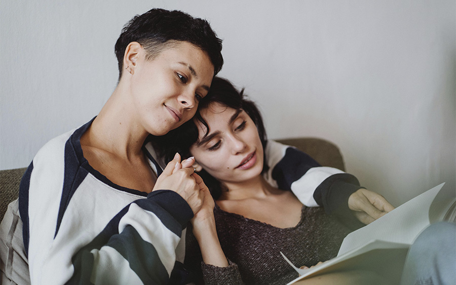 Couple reading a book and holding hands, representing how books on infidelity can help couples rebuild trust and heal.