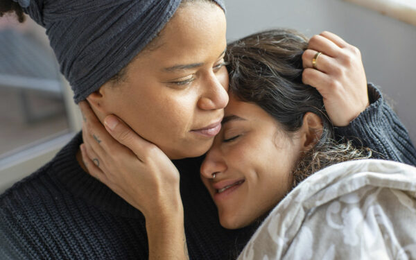 LGBTQ couple hugging each other, representing how you can navigate political differences and uncertainty in relationships together.