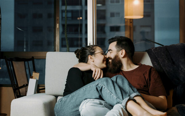 Couple sitting on the couch having a cute moment of connection, after taking the first steps into the defining the relationship talk.