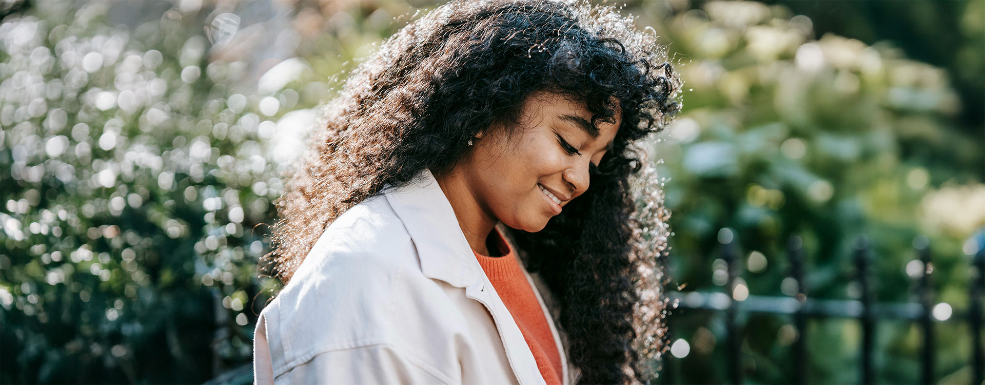 obsessive-compulsive-treatment-ocd-baltimore-new-connections-counseling-center-md Smiling black woman in park on a sunny day, represents how you can find happiness and peace after obsessive compulsive disorder therapy in Baltimore, MD.