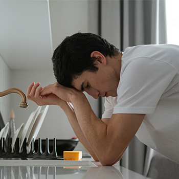 Man bent over the sink before breaking free from OCD through therapy services in Baltimore, MD.