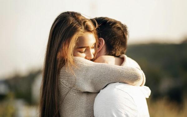 Young woman hugging her partner tightly, represents how an anxious attachment style in relationships can feel both thrilling and uncertain.