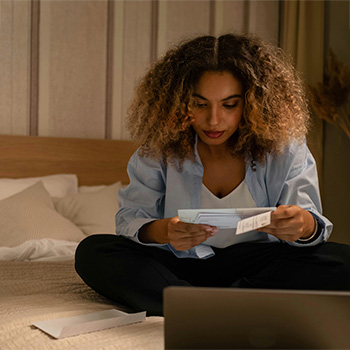 Person sitting in bed reading a letter, represents how you can find compassionate, inclusive support through gender affirmation letter and evaluation in Baltimore, MD.