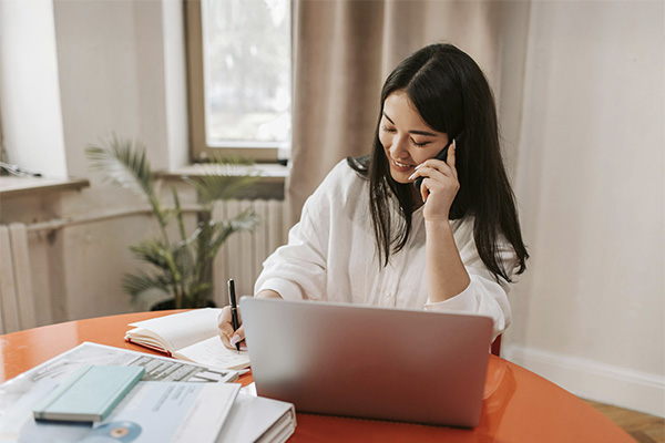 Woman working and talking on the phone, represents how ADHD therapy can help you reach your goals.